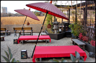 Tische mit Sonnenschirm im Garten eines Restaurants