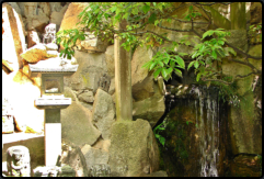 Wasserfall und Steinlaterne mit Buddha im Mitaki Temple